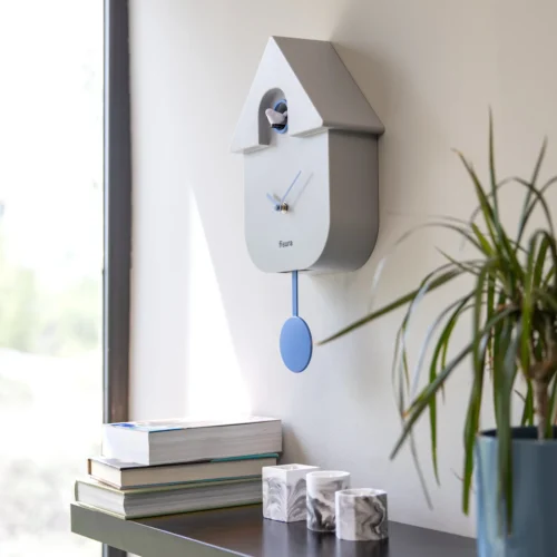 Fisura minimalist cuckoo clock in soft grey with blue pendulum and hands