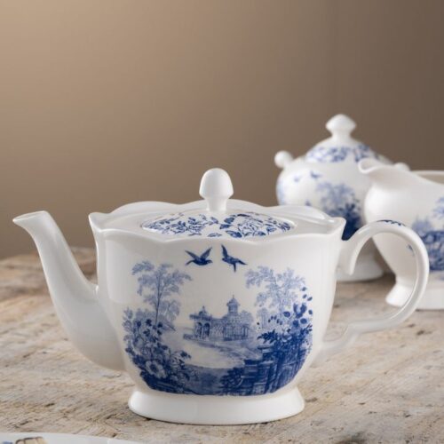 Aynsley Archive Blue fine china teapot featuring historic blue and white pastoral artwork with matching sugar bowl and creamer on a rustic wooden table.