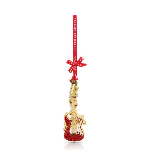 An elegant Tipperary Crystal Pearl Guitar Christmas tree ornament isolated on a clean white background. The gold-toned metal electric guitar features a vibrant red lower body entirely encrusted with sparkling ruby-red crystal rhinestones. The guitar's pickguard and headstock are decorated with glossy white faux pearls, while a swirling gold filigree wire dotted with clear crystal musical notes wraps around the guitar neck. The ornament hangs vertically from a bright red satin ribbon adorned with a bow and the text "Tipperary Crystal".